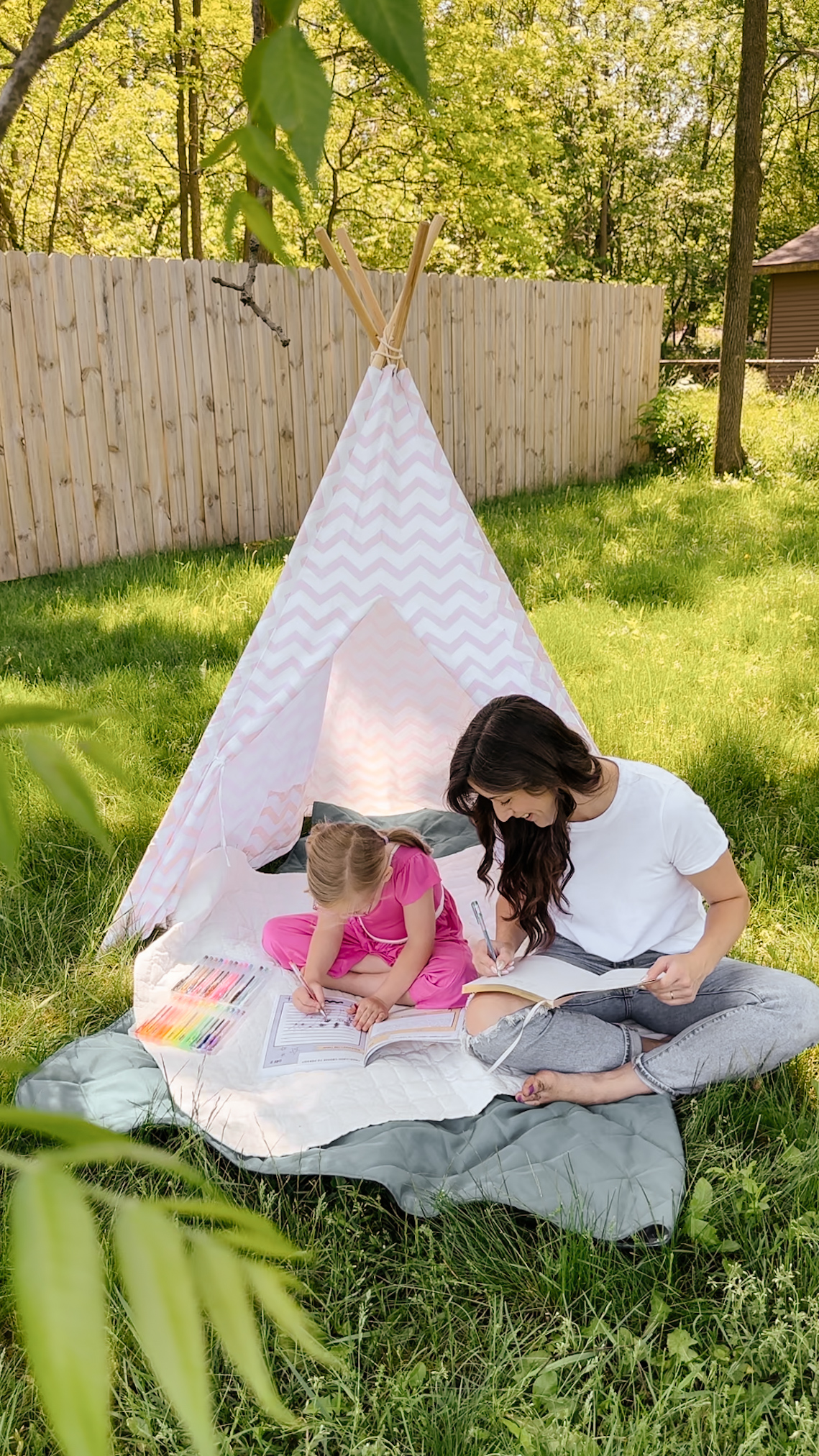 Mom and daughter coloring together in backyard