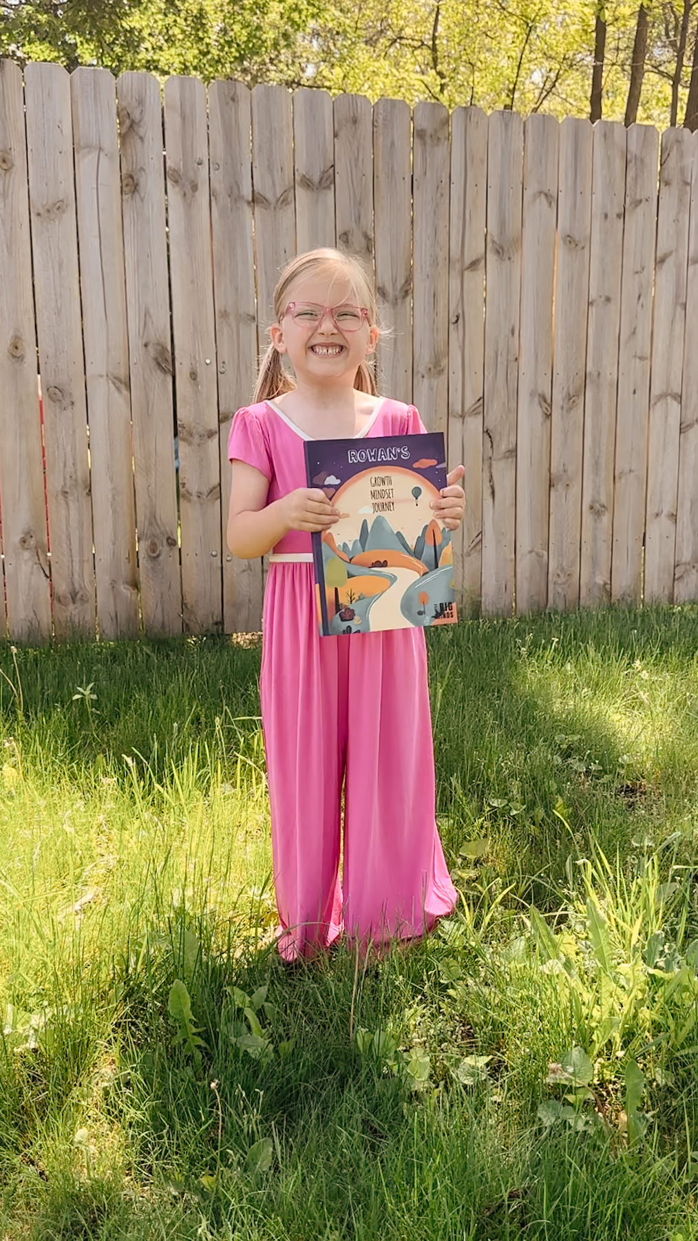 Girl proudly holding up her personalized book