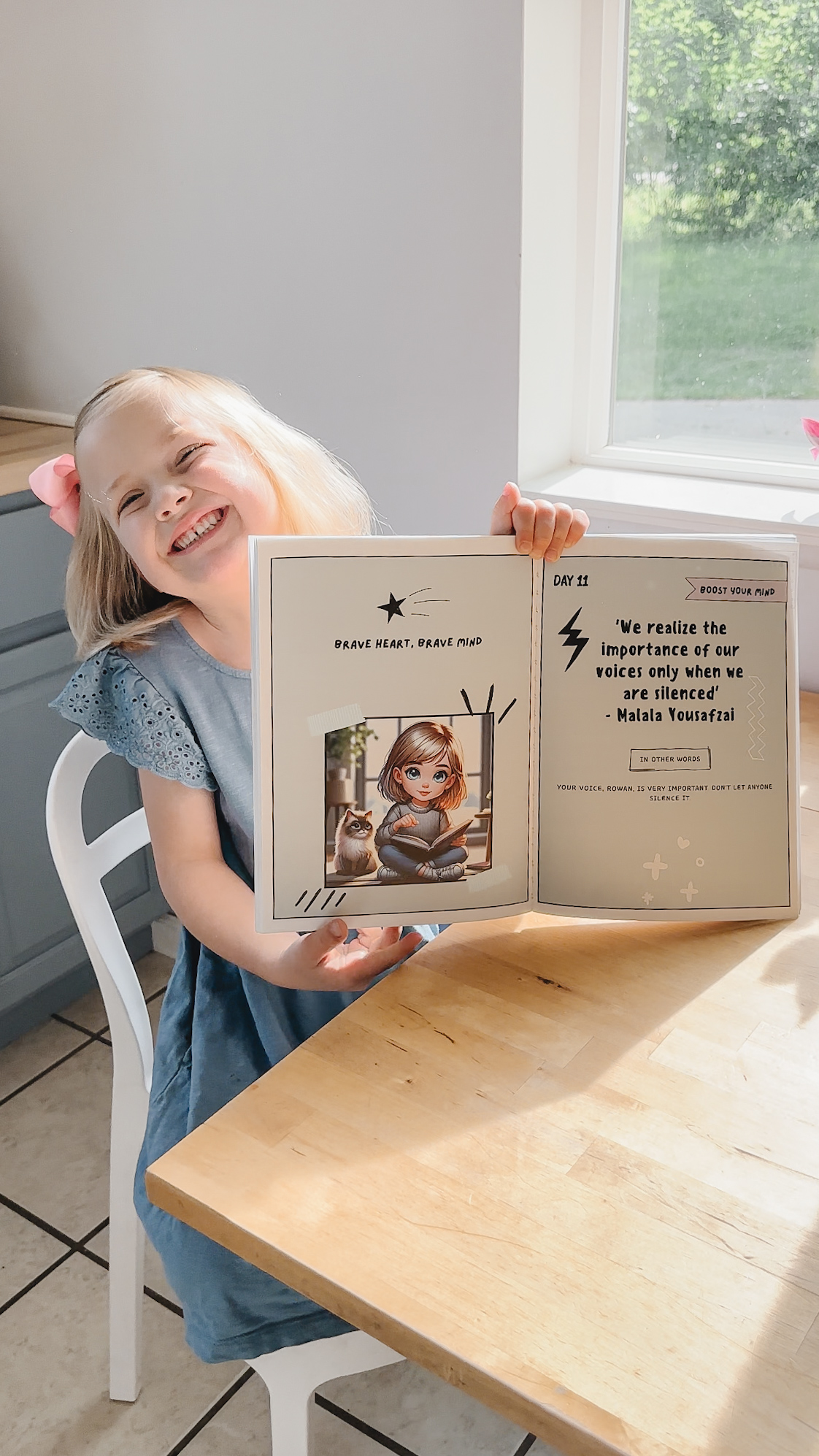 Girl beaming, holding open personalized book showing 'Brave Heart, Brave Mind'
