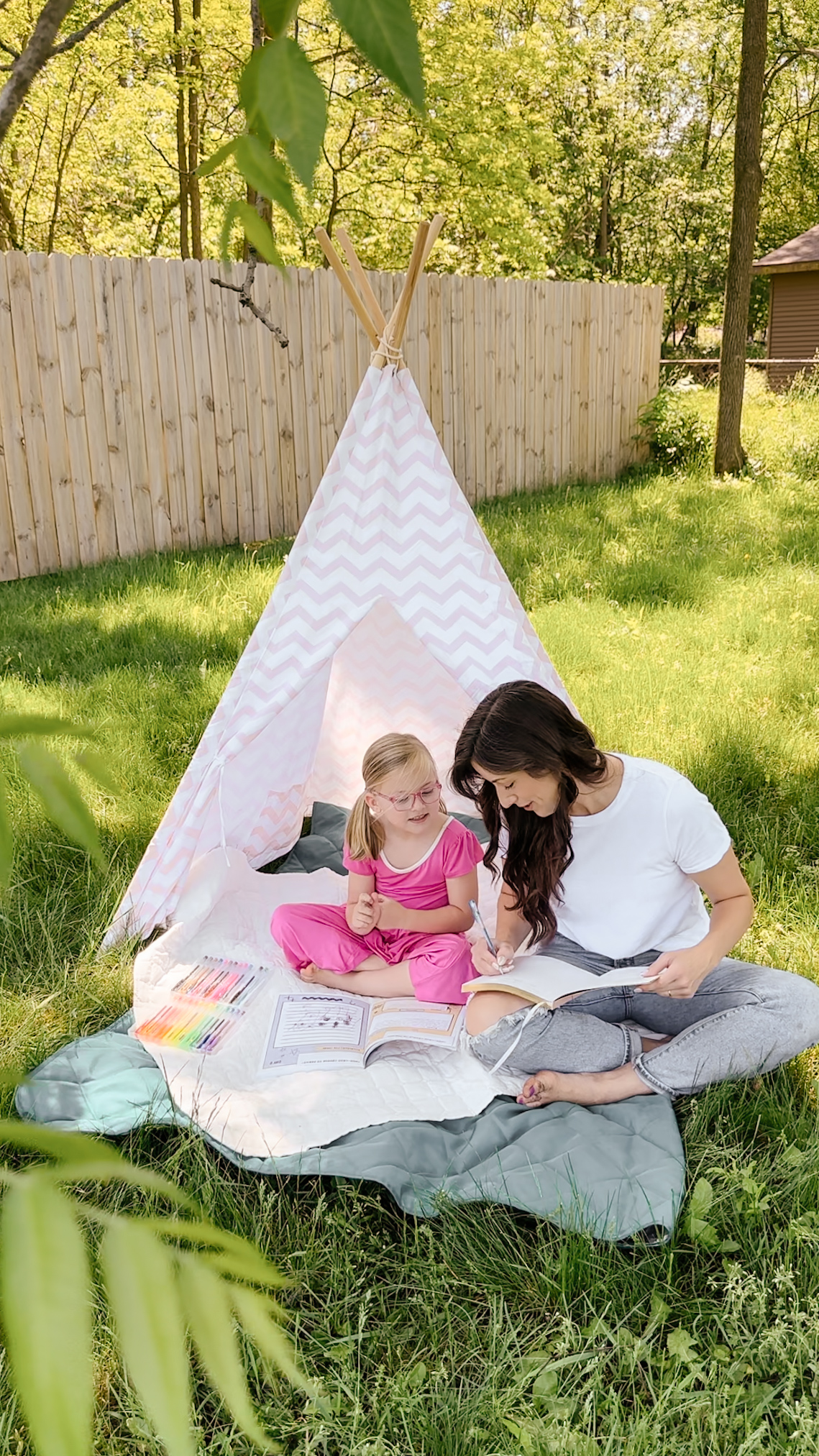 Mom and daughter together reading personalized book at teepee